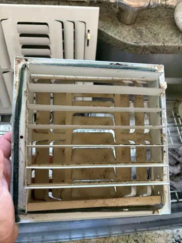 Grime on a register cover removed during a cleaning, Shirley, NY